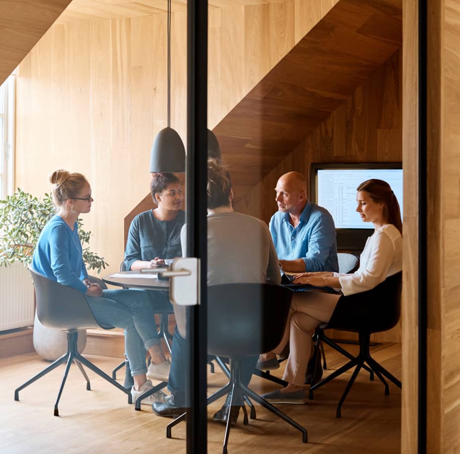 Several professionals in a meeting room with modern wooden decoration